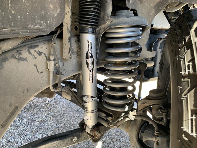 Passenger side front shock and progressive coil spring