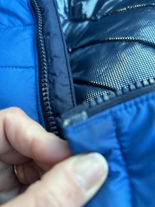 Zipper tooth missing (stitched in place to hold zipper on) and plastic splitting