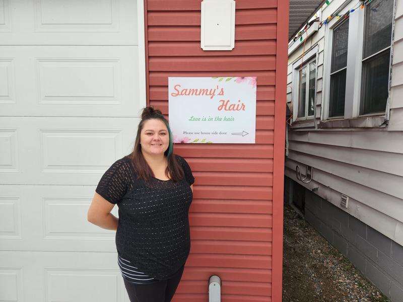 My wife beside the sign we hung with it