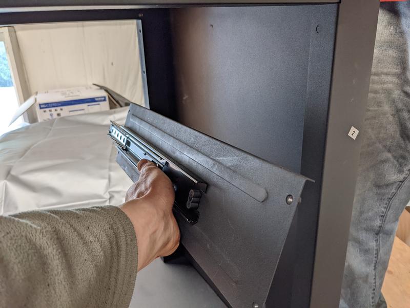 missing hole that had to be drilled (the front lower hole; there are four screws that fix the part being held in this photo)