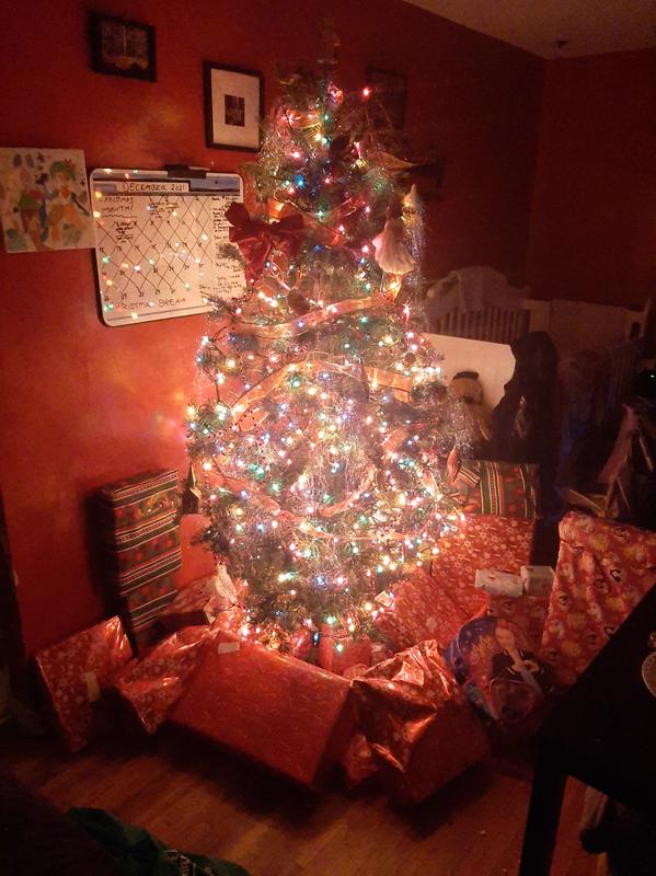 The tree on christmas morning being held up by the Santa Solutions Tree Stand