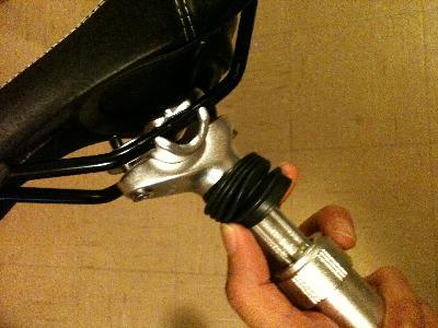 view of the seat rail mounting, suspension shaft (under the boot) and the lateral adjustment bezel