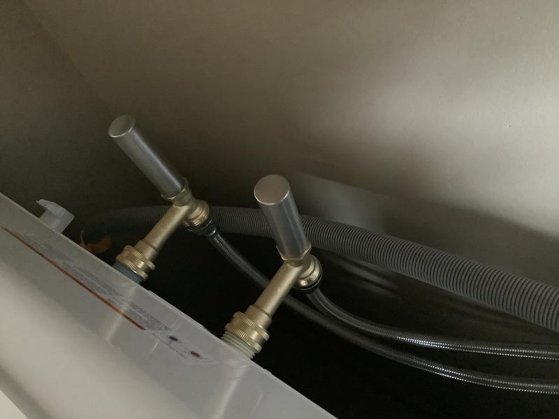 Back of washer.  Arrestors attached to machine, water hoses attached to arrestors