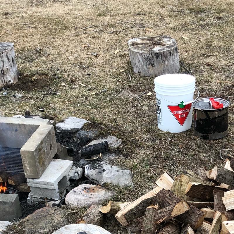 Getting ready to boil sap. Note the red plastic opening lever on the pot beside the bucket!