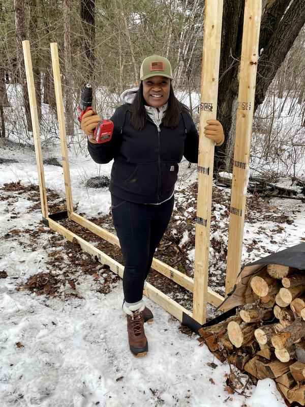 Afro-Latina homesteader building firewood racks in the Northwoods.