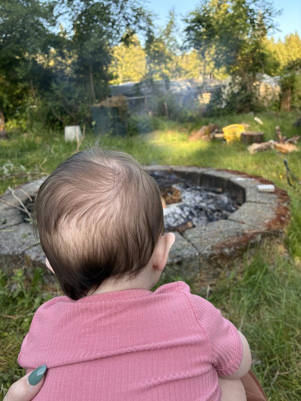 Hanging in romper with baby outside by the fire.
