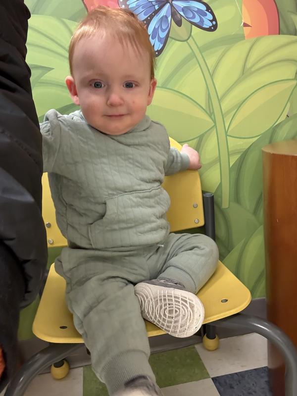 Showcasing pullover while sitting on a chair