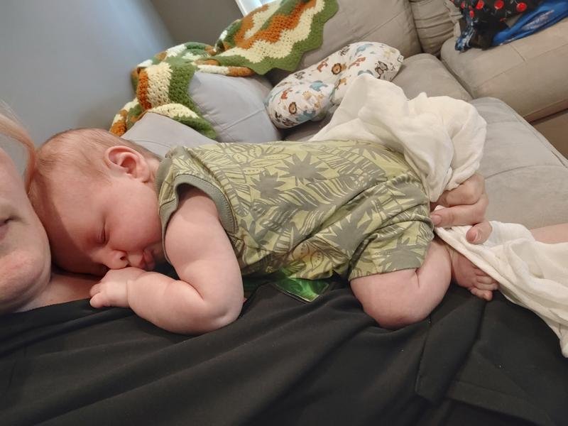 Baby all comfy taking a nap on mom in his new romper