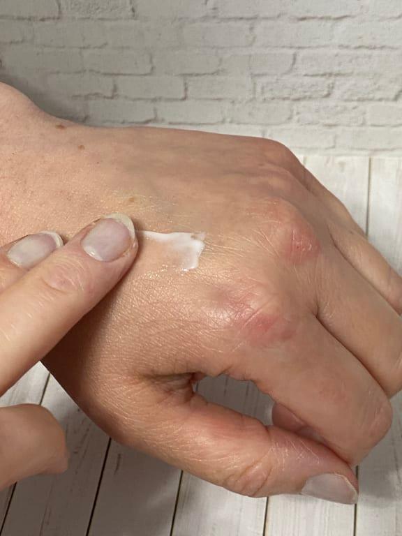 Applying Clé de Peau Advanced Intensive Night Cream on hand for demonstration