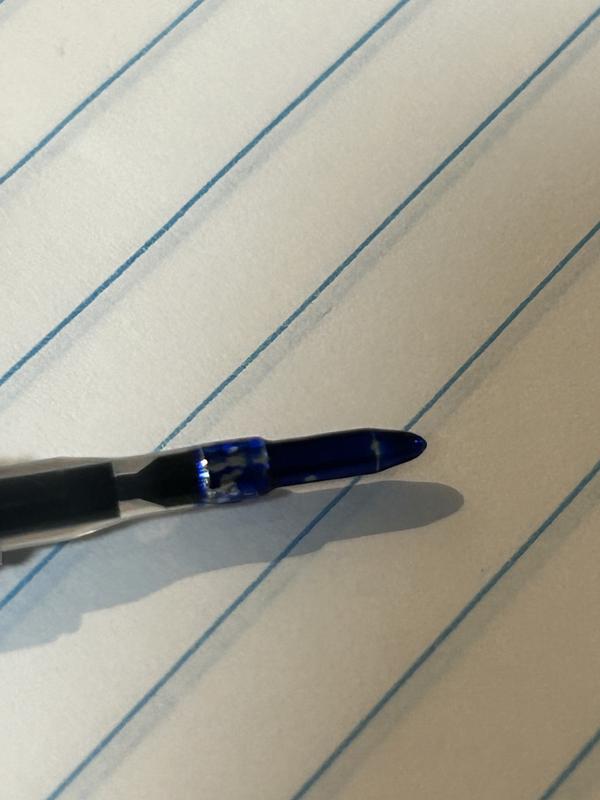 blue ink pooling at the juncture of pen tip and plastic well.