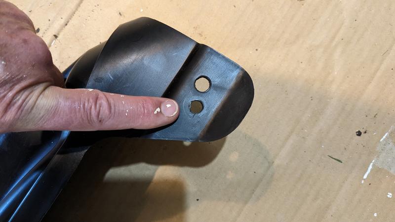 newly drilled hole in mulch plug to position it on the mowing deck correctly.