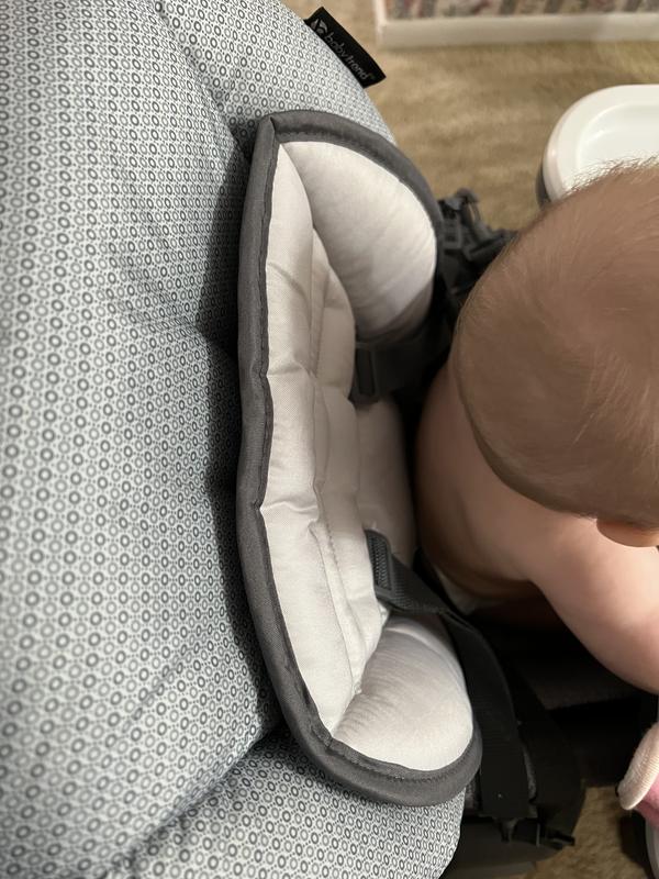 Baby sitting up straight, looking down at how the back has a recline at the most upright setting.
