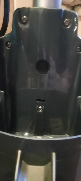 Behind the solution bottle. Button to disconnect the handle from the body.