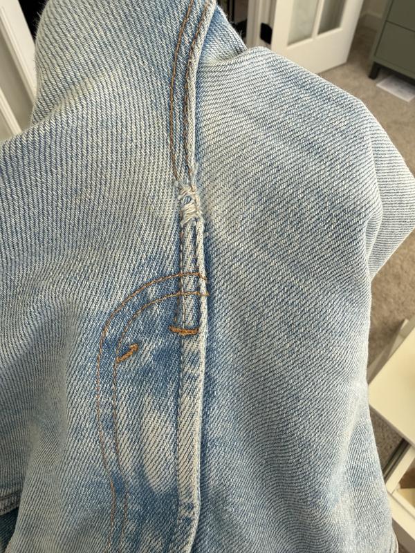 It appears the jeans were ripped, then stitched by hand? Right at the crotch