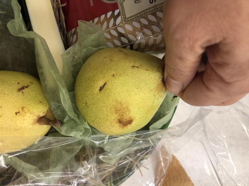 Fresh pears in male hands. Juicy flavorful pears in box, basket