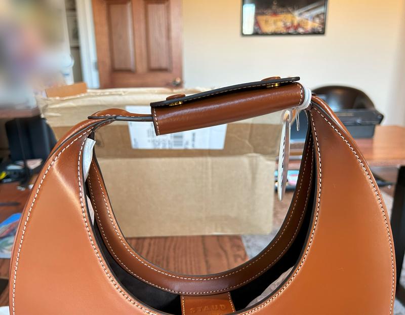 Collapsed/disfigured handle and top of purse due to it being stuffed into the box.