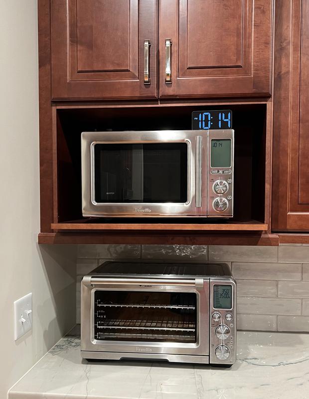 Microwave in the kitchen with lights on.