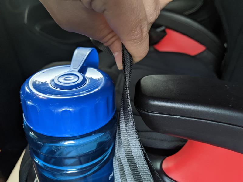 Seatbelt path with water bottle in cup holder