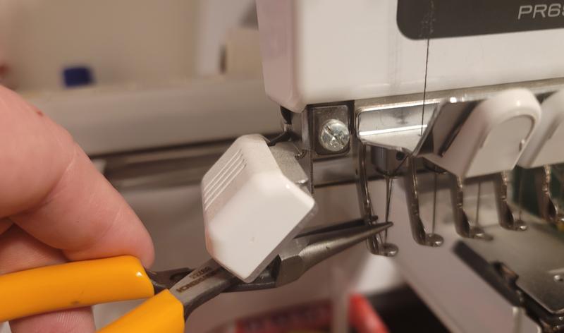 Me removing a stuck needle from an embroidery machine.
