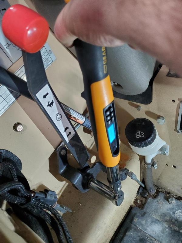 Torqueing the free play resistance on the throttle lever of a military version of a Case skid steer.