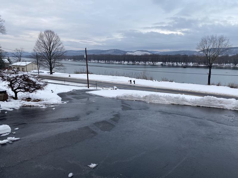 The pad at the top of hill and driveway snaking down, after a day of melting