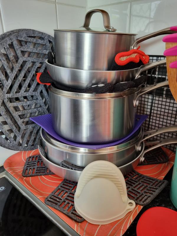 Most used cookware stacks well beside stove with protection between cookware pieces for protection.