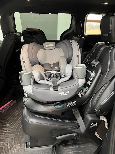 Red to Green indicators to say the seat belt is tight.| Seat hanging between captain's chairs while installing.| Rear Facing| Rotated toward the door.| Wire that connects the seat to the base.