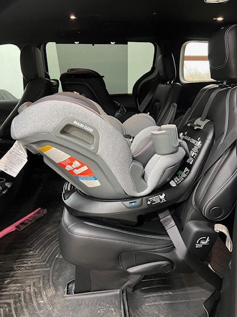 Red to Green indicators to say the seat belt is tight.| Seat hanging between captain's chairs while installing.| Rear Facing| Rotated toward the door.| Wire that connects the seat to the base.