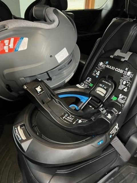 Red to Green indicators to say the seat belt is tight.| Seat hanging between captain's chairs while installing.| Rear Facing| Rotated toward the door.| Wire that connects the seat to the base.