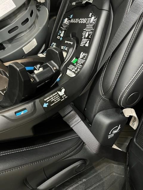 Red to Green indicators to say the seat belt is tight.| Seat hanging between captain's chairs while installing.| Rear Facing| Rotated toward the door.| Wire that connects the seat to the base.