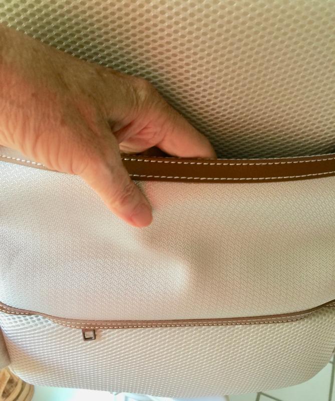 Zippered pocket as long as you leave the bottom zip closed. Otherwise it fits over the handle of the suitcase for carrying entire bag.