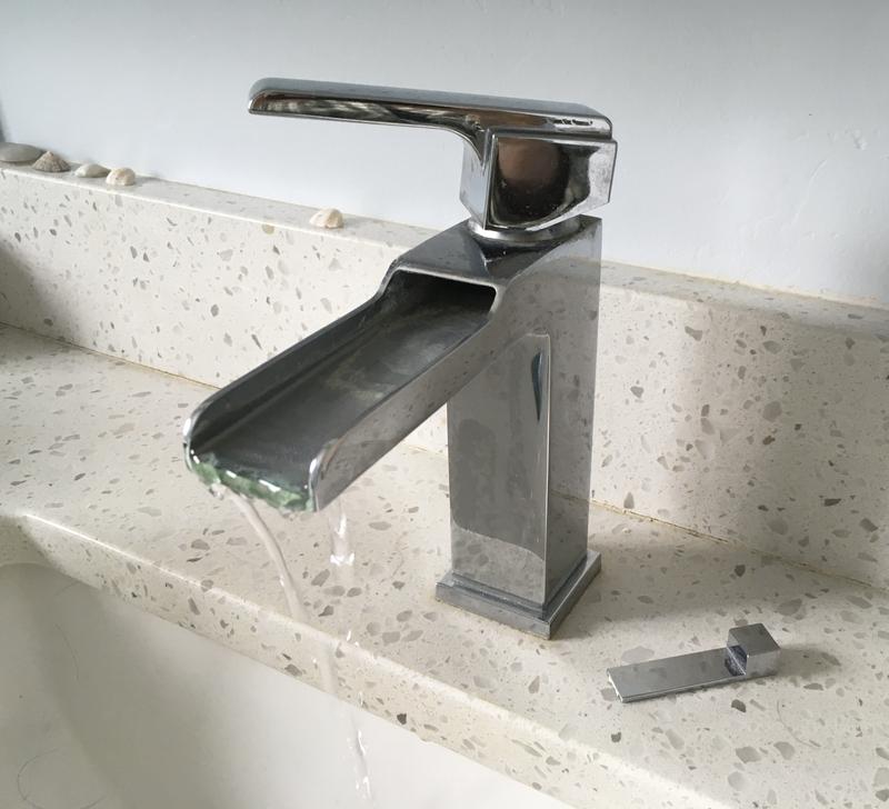 Broken drain tab behind faucet.