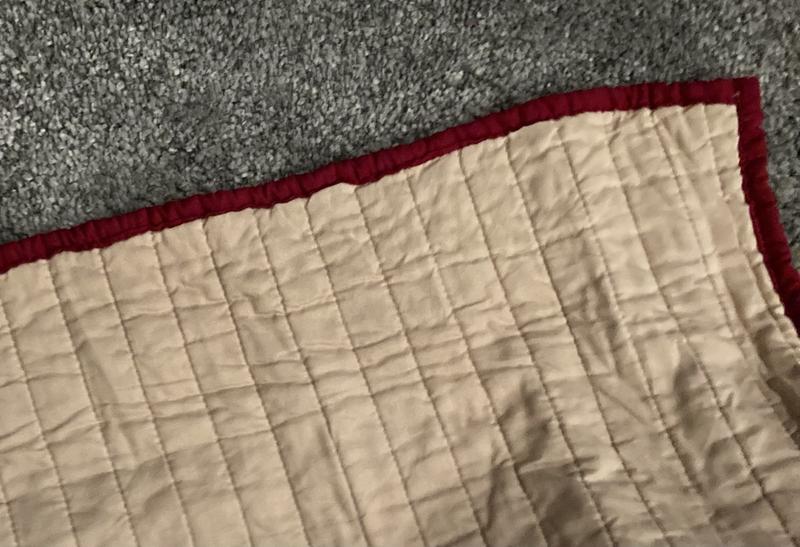 The cream colored reverse side is trimmed in dark burgundy red