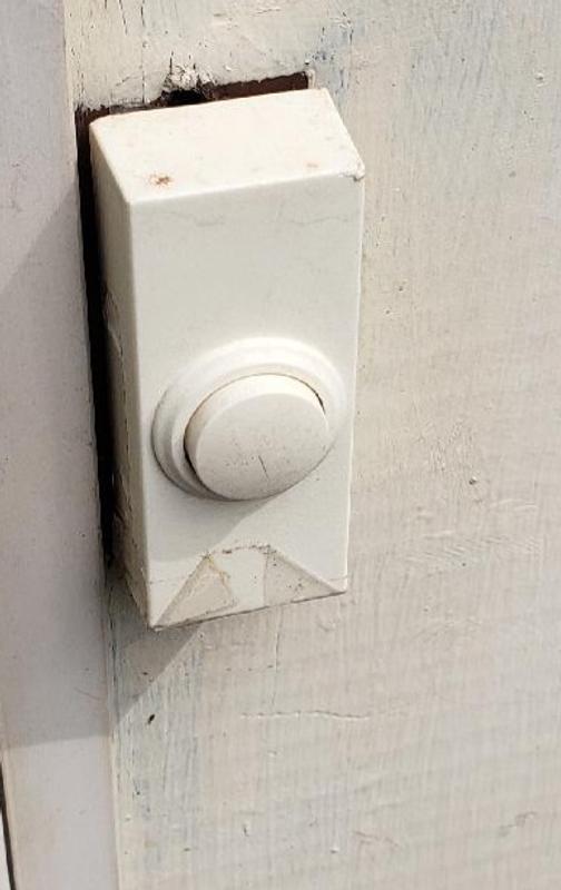 Doorbell attached to the door frame with the Alien Tape.