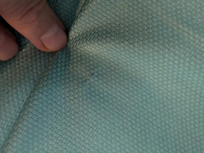 I know it's hard to see now, but we pushed the protruding fabric back into the jersey as best as possible with a pin.  It's still snagged, and will prob need repairing again after we wash it