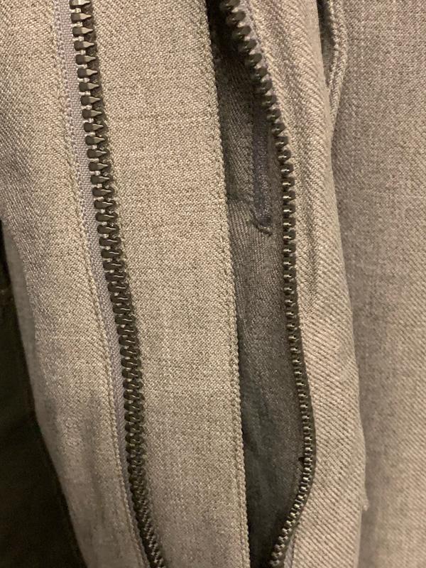 1st photo shows fraying on sleeve after 3 outings while wearing gloves. 2nd & 3rd photos show zipper as seen looking at the jacket from front.  The red oval shows the inner "shield" to keep air from coming through zipper: no insulation, just fabric.
