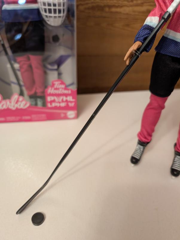Elastic holding the hockey stick to the doll's hand
