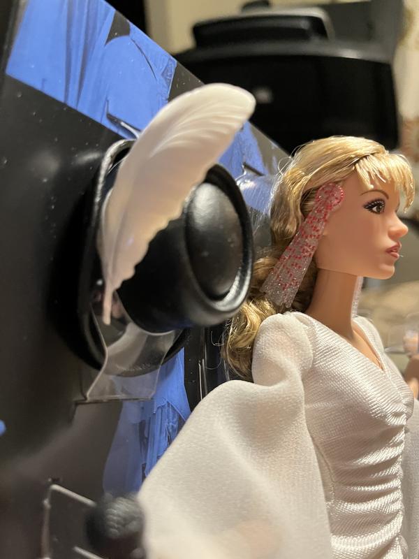 Black top hat with white feather and the white feather does move .