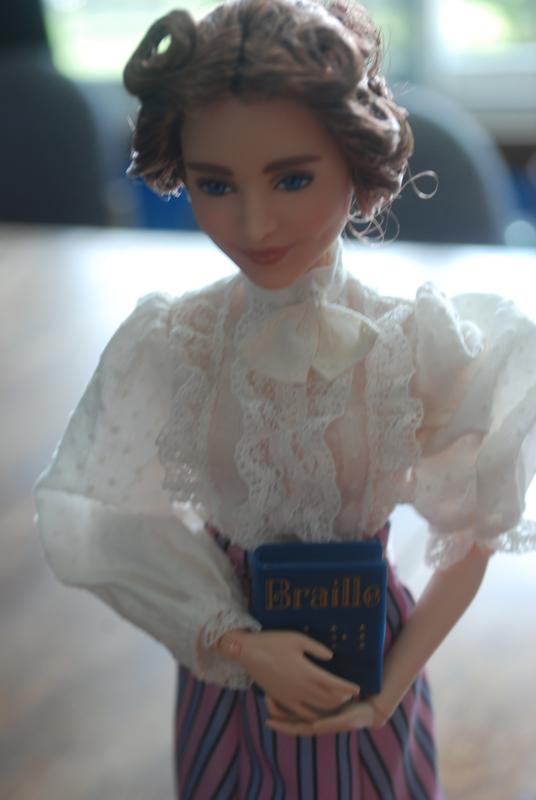 Showing the detailing in her shirt, as well as posing to hold her book.