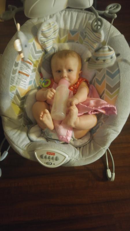Daughter enjoying a bottle while playing with her feet in her favorite chair