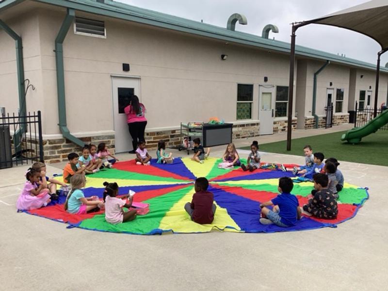 Kids having a blast with our parachute game, where each color means a different fun action!
