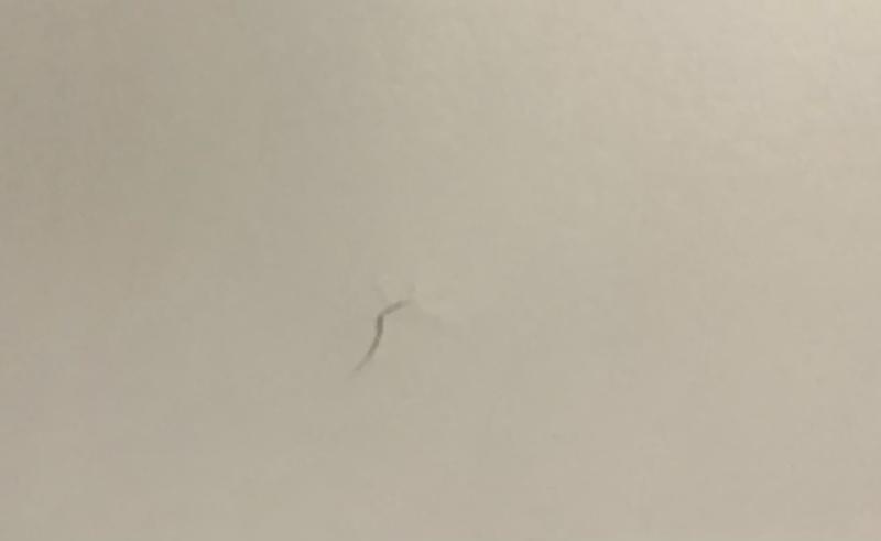 A second screw, halfway screwed in splitting the wood at the top of the desk.