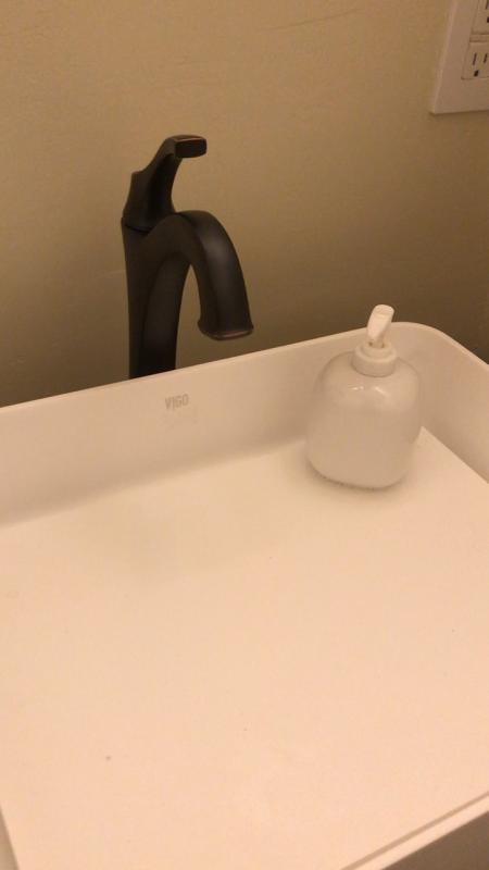 Oil-rubbed bronze faucet paired with an infinity edge vessel sink.