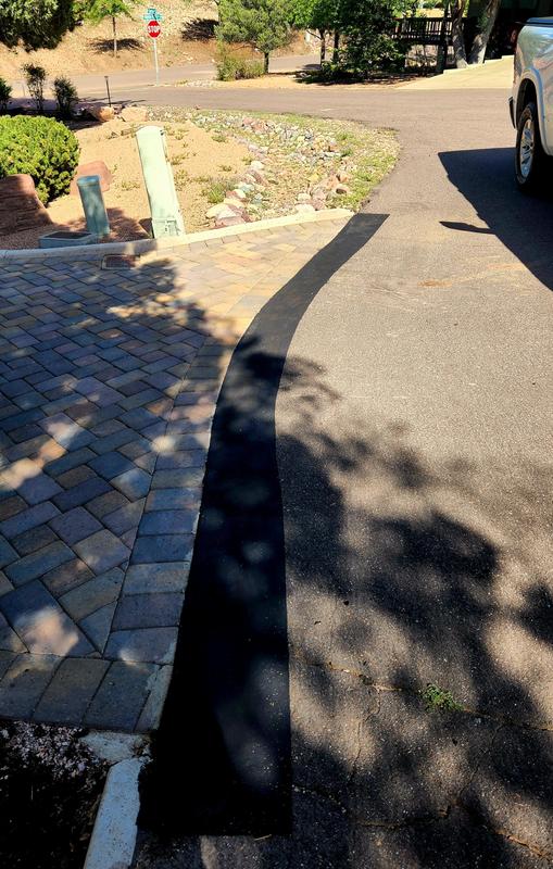 Cracked Asphalt Road with Houses and Cars in the Background Stock