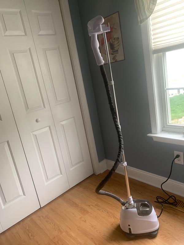 extended garment pole with attachment on top to hold garments and steamer hose