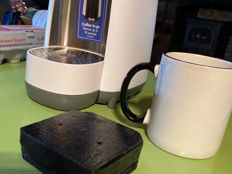 the block he made to boost the mug so the coffee doesnt splash out as much