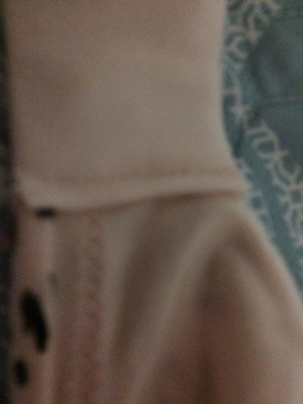 Poorly sewn seam by hooks in back