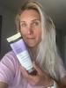 blonde girl holding a conditioner bottle