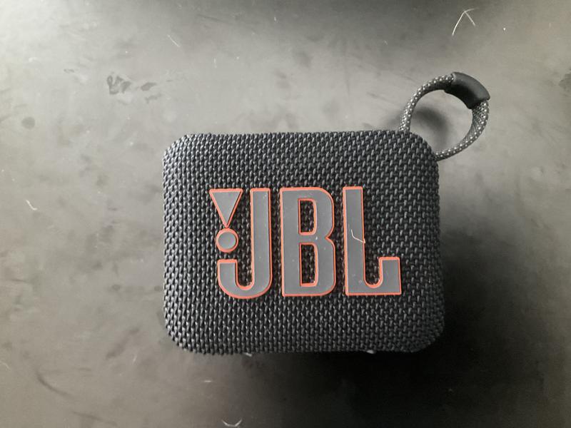 The first photo shows the JBL Go4 without the cover, and the second photo shows it with the cover.