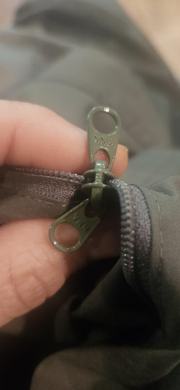 The right pocket has a zipper pull on inside and outside. This is the pocket it packs into.